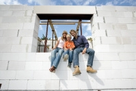 Familie im Fenster eines Bausatzhauses